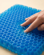 Main pressant le gel alvéolé du coussin pour montrer la répartition du poids