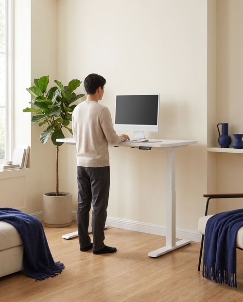 Personne travaillant debout au bureau assis-debout électrique