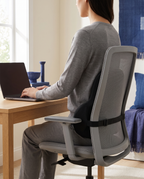Personne assise au bureau, bas du dos soutenu par le coussin lombaire